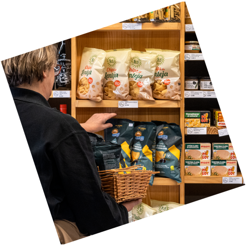 Treballadora de Cal Romesco reposant productes d'alimentació